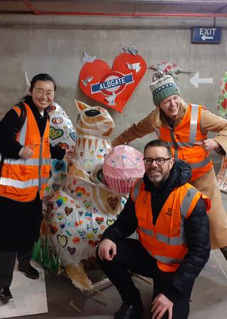 Three people standing around a large paper lantern 