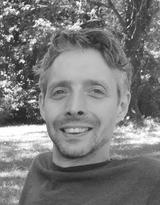 Black and white image of Jaime sitting outside in grass